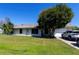 Attractive home with a lush green lawn, mature trees, and a driveway with parked cars at 950 Windway Cir, Kissimmee, FL 34744