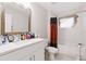 Bathroom with white vanity, modern sink, wood framed mirror and shower/bath combination with patterned curtain at 999 Trumbull St, Deltona, FL 32725