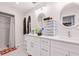 Bright bathroom featuring double sinks, white cabinets, modern fixtures, and a walk-in shower at 999 Trumbull St, Deltona, FL 32725