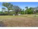 Expansive backyard featuring a small white building and black fencing amongst mature trees at 1560 S Pearl St, Deland, FL 32720