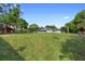 Large, grassy backyard featuring the house and additional barn structures, under a clear sky at 1560 S Pearl St, Deland, FL 32720