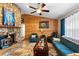 Comfortable living room with a stone fireplace and wood paneled accent wall at 1560 S Pearl St, Deland, FL 32720