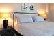 Cozy bedroom featuring nautical wall art, bedside lamps, and comfortable bedding at 1 Oceans West Blvd # 20B4, Daytona Beach, FL 32118