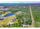 Expansive aerial view of the property showing lush greenery, multiple ponds, and distant Lake Ashby at 1015 Tallacoe Trl, New Smyrna Beach, FL 32168