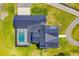 Aerial view of the property showcasing the house layout, roof design, pool, and surrounding landscaping at 1015 Tallacoe Trl, New Smyrna Beach, FL 32168