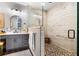 Modern bathroom with gray vanity, vessel sinks, and a frameless glass shower with decorative tile and a bench at 1015 Tallacoe Trl, New Smyrna Beach, FL 32168