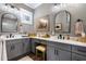 Bathroom featuring double sinks, gray cabinetry, quartz counters, modern fixtures, and framed mirrors at 1015 Tallacoe Trl, New Smyrna Beach, FL 32168