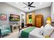 Bedroom featuring a modern ceiling fan, television, and a bright window with colorful curtains at 1015 Tallacoe Trl, New Smyrna Beach, FL 32168