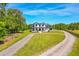 Stunning aerial view of a modern farmhouse with a long driveway and well-manicured lawn at 1015 Tallacoe Trl, New Smyrna Beach, FL 32168
