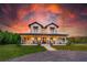 Beautiful farmhouse-style home with a classic front porch, surrounded by lush landscaping at 1015 Tallacoe Trl, New Smyrna Beach, FL 32168