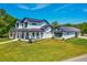Beautifully landscaped two-story modern farmhouse with black metal roof and inviting front porch at 1015 Tallacoe Trl, New Smyrna Beach, FL 32168