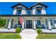 Elegant two-story farmhouse with a covered front porch and pristine landscaping at 1015 Tallacoe Trl, New Smyrna Beach, FL 32168