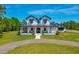 Charming two-story farmhouse with a welcoming front porch and a perfectly manicured front lawn at 1015 Tallacoe Trl, New Smyrna Beach, FL 32168