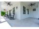 Inviting front porch featuring rocking chairs, tile flooring, and ceiling fans, perfect for relaxing outdoors at 1015 Tallacoe Trl, New Smyrna Beach, FL 32168