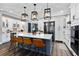 Modern kitchen with white cabinets, a large island, stylish pendant lighting, and stainless steel appliances at 1015 Tallacoe Trl, New Smyrna Beach, FL 32168