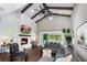 Spacious living room with vaulted ceilings, wood beams, a cozy fireplace, and comfortable seating at 1015 Tallacoe Trl, New Smyrna Beach, FL 32168