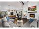 Open-concept living area featuring a fireplace, vaulted ceiling, comfortable seating, and seamless kitchen access at 1015 Tallacoe Trl, New Smyrna Beach, FL 32168