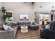 Spacious living room featuring a large sectional sofa, stylish decor, and an open floor plan flowing into the kitchen at 1015 Tallacoe Trl, New Smyrna Beach, FL 32168