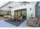 Covered outdoor dining area with stylish table set, ceiling fans, and access to an outdoor sitting area at 1015 Tallacoe Trl, New Smyrna Beach, FL 32168