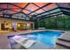 Luxurious screened-in pool with lounge chairs and built-in lighting for evening enjoyment at 1015 Tallacoe Trl, New Smyrna Beach, FL 32168