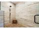 Stylish shower with a frameless glass door, decorative tile walls, river rock floor, and a sleek shower head at 1015 Tallacoe Trl, New Smyrna Beach, FL 32168
