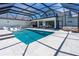 Stunning screened-in pool area with elegant lounge furniture, water features, and an outdoor dining space at 1015 Tallacoe Trl, New Smyrna Beach, FL 32168