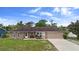 Charming single-story brick home with a well-manicured lawn, attached garage, and inviting front entrance at 1054 Abeline Dr, Deltona, FL 32725