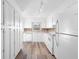 Bright kitchen with white cabinets, backsplash, modern appliances, and wood flooring at 1054 Abeline Dr, Deltona, FL 32725