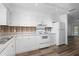 Bright kitchen features all-white cabinetry, stainless sink, white appliances, and tiled backsplash at 1054 Abeline Dr, Deltona, FL 32725