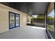 A screened patio featuring french doors, with view of a grassy yard at 1054 Abeline Dr, Deltona, FL 32725