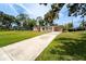 Ranch style home with pink siding, a concrete driveway, lush green lawn, and mature trees at 1160 Fountainhead Dr, Deltona, FL 32725