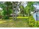 Expansive backyard with mature trees, a green lawn, and a charming home, offering ample space for outdoor enjoyment at 1206 Parkside Dr, Ormond Beach, FL 32174