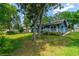 Lovely backyard featuring a well-maintained lawn, mature trees, and a cozy blue home, perfect for outdoor activities at 1206 Parkside Dr, Ormond Beach, FL 32174