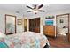 Spacious bedroom featuring hardwood floors, a ceiling fan, and access to the bathroom and closet at 1206 Parkside Dr, Ormond Beach, FL 32174