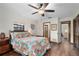 Bright bedroom with hardwood floors, ceiling fan, windows, and colorful floral bedding at 1206 Parkside Dr, Ormond Beach, FL 32174