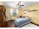 A bright bedroom with hardwood floors, a floral curtain, and a classic dresser at 1206 Parkside Dr, Ormond Beach, FL 32174