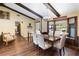 Elegant dining room with hardwood floors, wood beam ceilings, and a view of the front yard from window seat at 1206 Parkside Dr, Ormond Beach, FL 32174