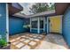 Inviting entryway with a yellow front door, stone pathway, and decorative plants adding a touch of charm at 1206 Parkside Dr, Ormond Beach, FL 32174