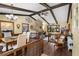 Cozy living room featuring a stone fireplace, wood beams, and hardwood floors providing a warm ambiance at 1206 Parkside Dr, Ormond Beach, FL 32174