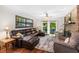 Inviting living room featuring hardwood floors, a brick fireplace, and a walkout to a private balcony at 1206 Parkside Dr, Ormond Beach, FL 32174