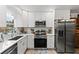 Bright kitchen features stainless steel appliances, white cabinets, and modern backsplash at 135 Moonstone Ct, Port Orange, FL 32129