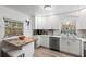 Bright, renovated kitchen features white cabinets, stainless steel appliances, and an adjacent dining area for seamless living at 135 Moonstone Ct, Port Orange, FL 32129