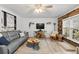 Bright living room with a gray sofa, hardwood floors, an accent wood wall, and plenty of natural light at 135 Moonstone Ct, Port Orange, FL 32129