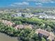 Stunning aerial view of the condo complex surrounded by lush trees and community buildings under a partly cloudy sky at 1401 S Palmetto Ave # 300, Daytona Beach, FL 32114