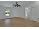Bright living room with wood-look flooring, ceiling fan, and a view of the front yard at 1427 18Th St, Orange City, FL 32763