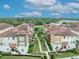Scenic aerial view of townhomes nestled between well-maintained green spaces and featuring a serene, tree-lined backdrop at 1436 Lobelia Dr, Lake Mary, FL 32746