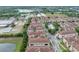 Aerial image of townhomes with terra cotta roofs surrounded by greenery, street layout, and nearby community facilities at 1436 Lobelia Dr, Lake Mary, FL 32746