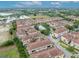 Aerial view of townhomes with tiled roofs and landscaping near open space and building construction at 1436 Lobelia Dr, Lake Mary, FL 32746