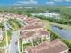 Aerial view of townhomes with tiled roofs, landscaped grounds, and a tranquil pond in a lush, green community at 1436 Lobelia Dr, Lake Mary, FL 32746