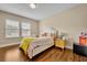 Cozy bedroom featuring a comfortable bed, bedside table, natural light, and wood flooring at 1436 Lobelia Dr, Lake Mary, FL 32746